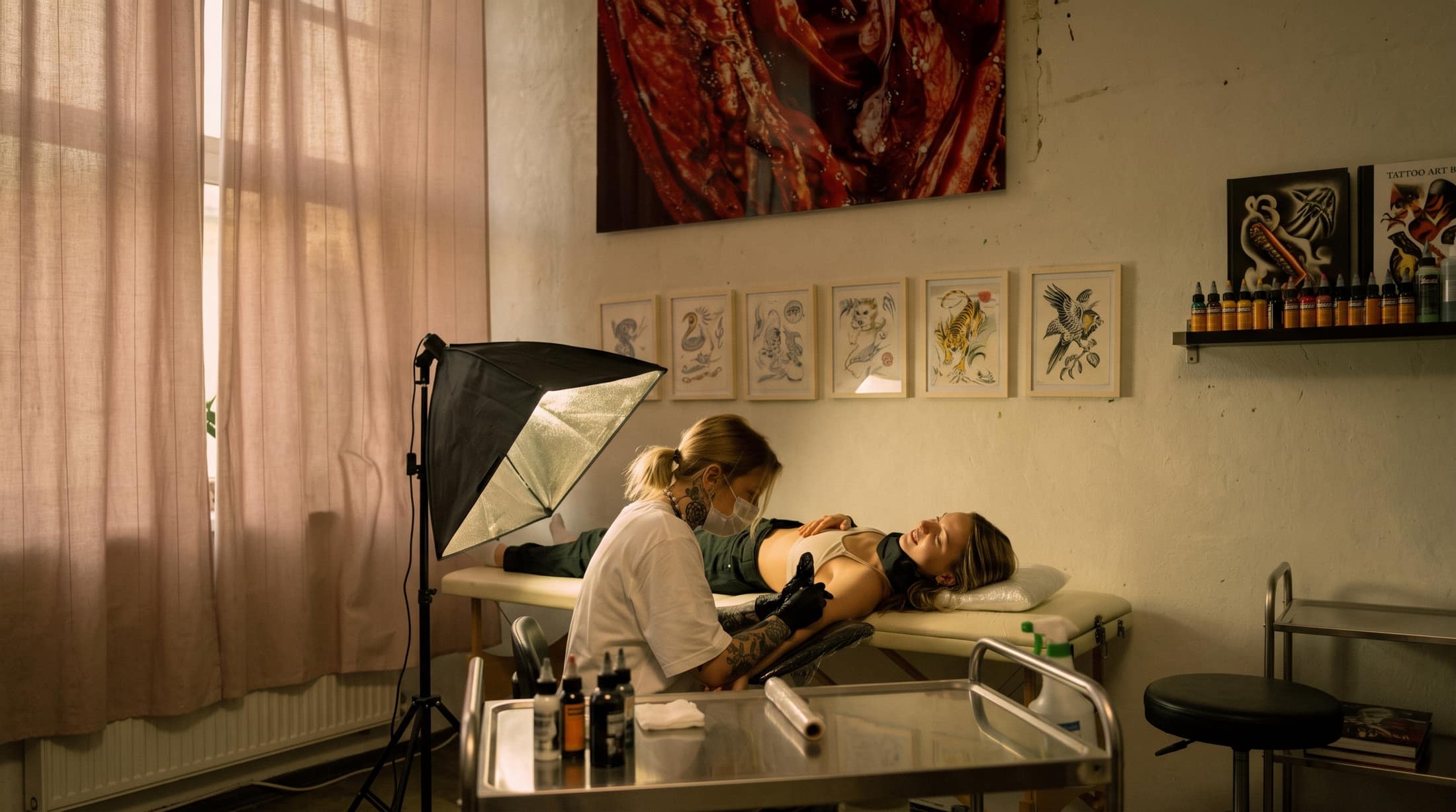 Tatuadora trabajando con concentración sobre una clienta en su estudio